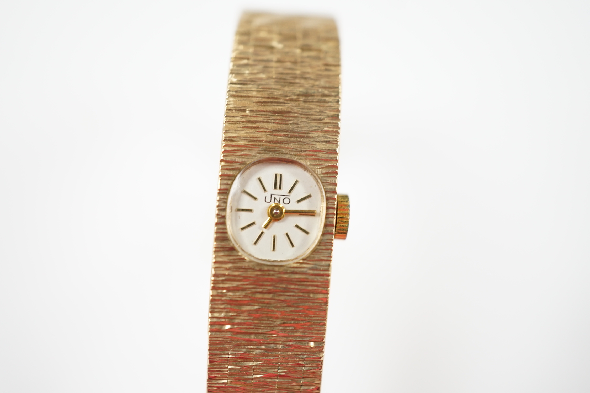 A lady's 1970's 9ct. gold Uno manual wind bracelet wrist watch with a bark textured bracelet, gross weight 24.8 grams.